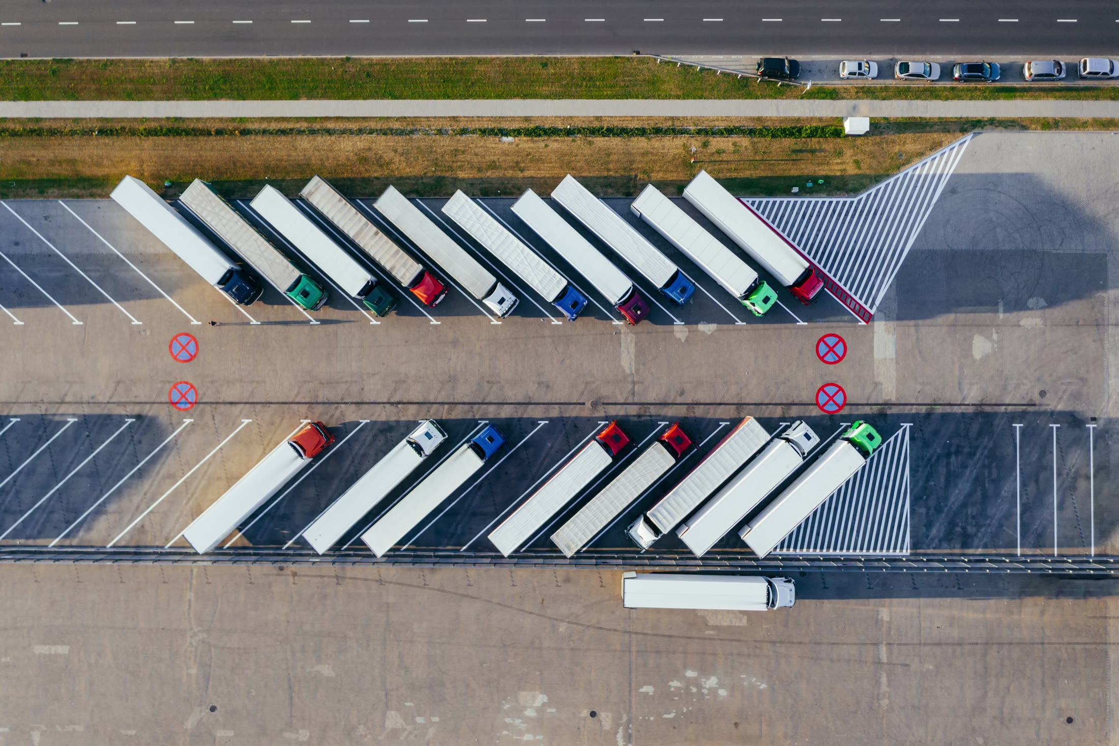 Commercial truck fleet viewed from above at a logistics stop